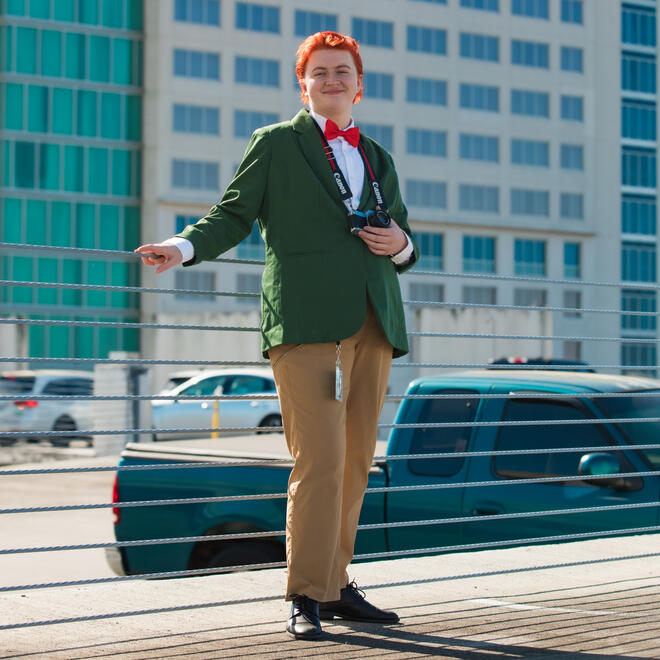 Brie, dressed as Jimmy Olsen from the Superman comics, looking out into the distance in an Orlando parking lot.