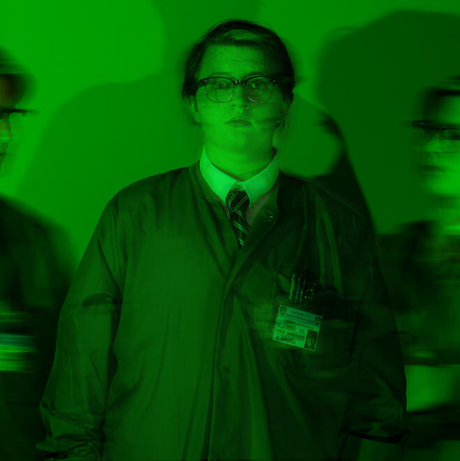 Brie, dressed as Ed Nygma from Gotham, looking scared into the camera, with blurry clones of him superimposed on his left and right.
