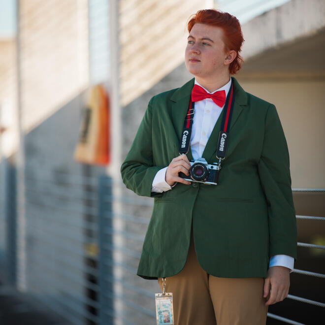 Brie, dressed as Jimmy Olsen from the Superman comics, looking out into the distance in an Orlando parking lot.